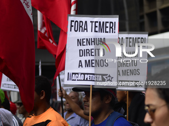 A demonstrator holds up a sign that reads 'Out Temer' during a workers union protest against President Michel Temer's government on Labor Da...