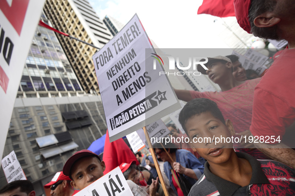 A demonstrator holds up a sign that reads 'Out Temer' during a workers union protest against President Michel Temer's government on Labor Da...