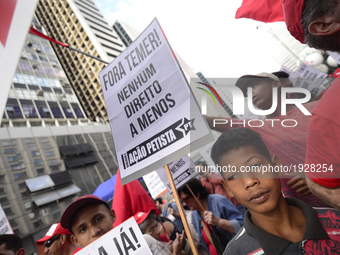 A demonstrator holds up a sign that reads 'Out Temer' during a workers union protest against President Michel Temer's government on Labor Da...