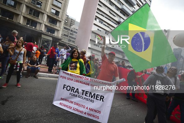 A demonstrator holds up a banner that reads 'Out Temer' during a workers union protest against President Michel Temer's government on Labor...