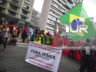 A demonstrator holds up a banner that reads 'Out Temer' during a workers union protest against President Michel Temer's government on Labor...