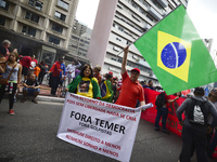 A demonstrator holds up a banner that reads 'Out Temer' during a workers union protest against President Michel Temer's government on Labor...