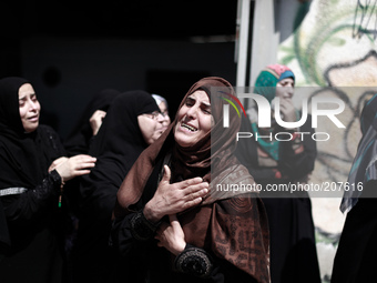 Relatives of nine Palestinians from the Abu Nejim family, whom medics said were killed by an Israeli air strike, mourn during their funeral...