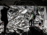 Palestinians search for the remains of bodies under the rubble of the Abu Nejim family house which witnesses said was destroyed by an Israel...
