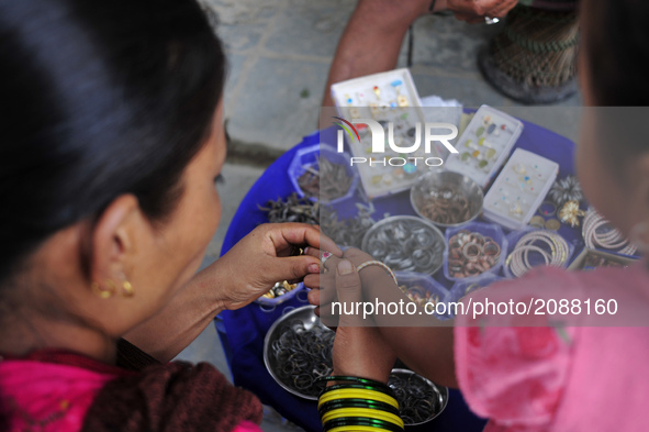 A Mother select ring to her child during Gathemangal festival in Kathmandu, Nepal on Friday, July 21, 2017. People wear metal rings to safeg...