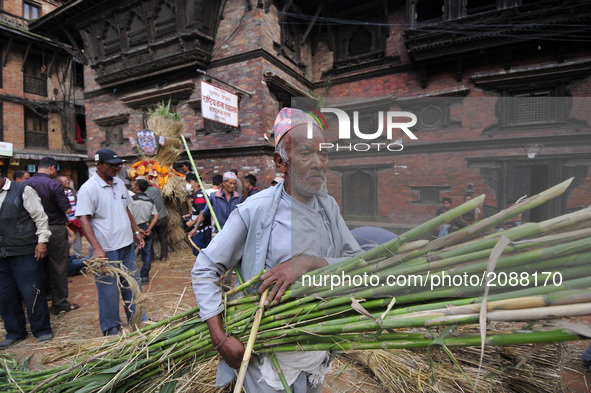 A Nepalese devotee carrying bamboo for making straw effigy demon Ghantakarna during the Gathemangal festival celebrated at Bhaktapur, Nepal...