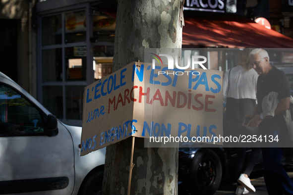 The placard reads 'School isn't a merchandise, neither our children'. More than 15000 protesters took to the streets of Toulouse against the...