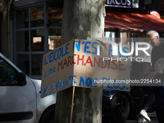 The placard reads 'School isn't a merchandise, neither our children'. More than 15000 protesters took to the streets of Toulouse against the...