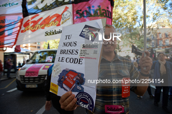 A man shows a placard reading 'You breaks us our Work code'. More than 15000 protesters took to the streets of Toulouse against the new Macr...