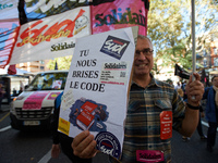 A man shows a placard reading 'You breaks us our Work code'. More than 15000 protesters took to the streets of Toulouse against the new Macr...