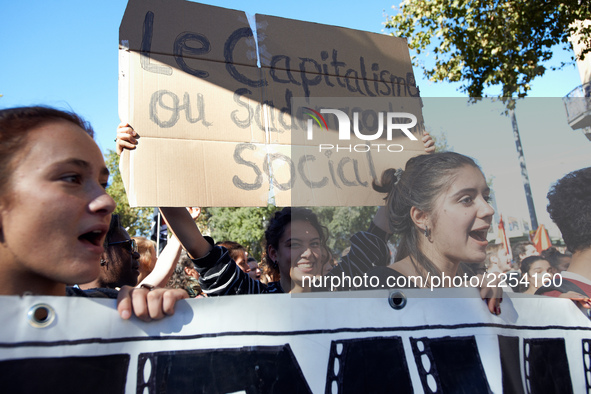 As students shout slogas, a student holds a placard reading 'Capitalism is social sadomasochism'. More than 15000 protesters took to the str...