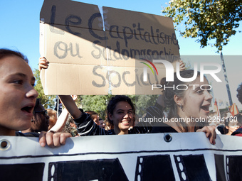 As students shout slogas, a student holds a placard reading 'Capitalism is social sadomasochism'. More than 15000 protesters took to the str...