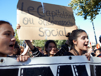 As students shout slogas, a student holds a placard reading 'Capitalism is social sadomasochism'. More than 15000 protesters took to the str...