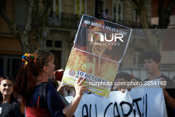 A woman shouts slogans against Macron while holding a placrad depicting French President Macron. More than 15000 protesters took to the stre...