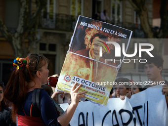 A woman shouts slogans against Macron while holding a placrad depicting French President Macron. More than 15000 protesters took to the stre...