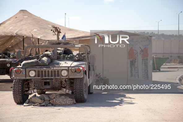 An Israeli soldier reads a book while resting at the outpost set up by IDF forces in Erez’s border crossing. Next to him a hand-paint remind...