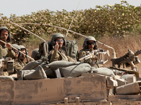 An Israeli tank crew drives back inside the Gaza Strip to continue with Israel’s Operation Margin Protector. (