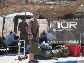 An Israeli soldier and his unit at the outpost located in Erez border crossing, hours after they made it back from fighting Hamas militants...