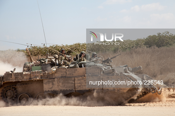 An Israeli tank crew wave as they go back into the fighting in the Gaza Strip. 