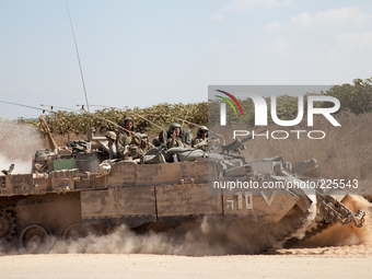 An Israeli tank crew wave as they go back into the fighting in the Gaza Strip. (