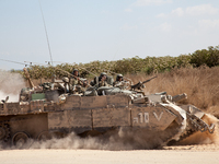 An Israeli tank crew wave as they go back into the fighting in the Gaza Strip. (