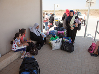 Palestinian children with their mothers waiting to cross the border Erez to go back inside Gaza despite the fighting there. (