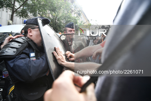 Metalworkers face off with police officers as they march with banners and flags in the streets of Paris on October 13, 2017. Several thousan...