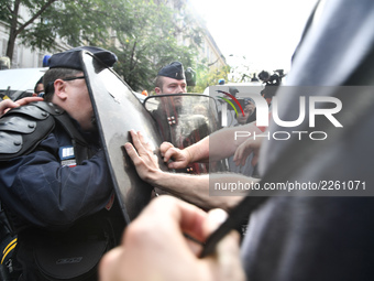 Metalworkers face off with police officers as they march with banners and flags in the streets of Paris on October 13, 2017. Several thousan...