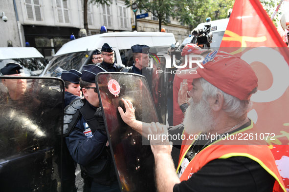 Metalworkers face off with police officers as they march with banners and flags in the streets of Paris on October 13, 2017. Several thousan...