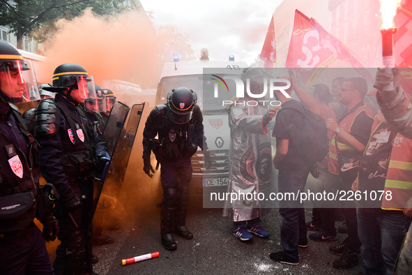 Metalworkers face off with police officers as they march with banners and flags in the streets of Paris on October 13, 2017. Several thousan...