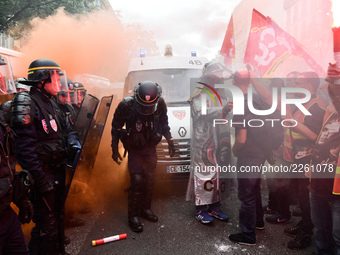 Metalworkers face off with police officers as they march with banners and flags in the streets of Paris on October 13, 2017. Several thousan...