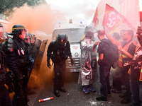 Metalworkers face off with police officers as they march with banners and flags in the streets of Paris on October 13, 2017. Several thousan...