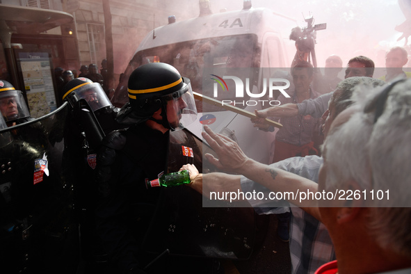 Police officers are surrounded by smoke as metalworkers demonstrate in Paris on October 13, 2017. Several thousand workers have taken part i...