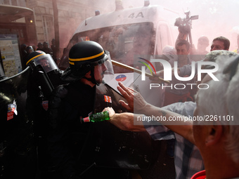 Police officers are surrounded by smoke as metalworkers demonstrate in Paris on October 13, 2017. Several thousand workers have taken part i...