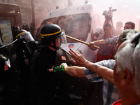 Police officers are surrounded by smoke as metalworkers demonstrate in Paris on October 13, 2017. Several thousand workers have taken part i...