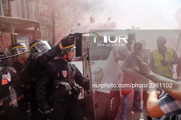 Police officers are surrounded by smoke as metalworkers demonstrate in Paris on October 13, 2017. Several thousand workers have taken part i...