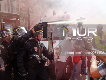 Police officers are surrounded by smoke as metalworkers demonstrate in Paris on October 13, 2017. Several thousand workers have taken part i...