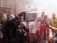 Police officers are surrounded by smoke as metalworkers demonstrate in Paris on October 13, 2017. Several thousand workers have taken part i...