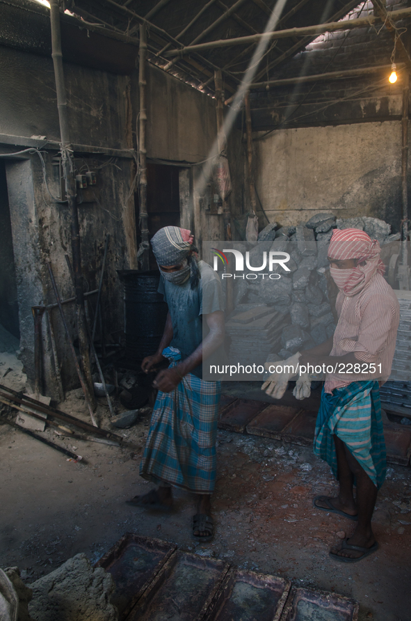 DHAKA, BANGLADESH. Juli  2013 Two workers are seen in the lead smelting mill, without any safety protection. Bangladesh has one of the highe...