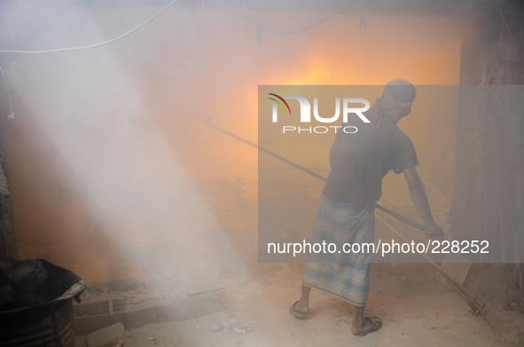 DHAKA, BANGLADESH. Juli  2013. Worker remove the lead slag with a scoop, without any safety protection. the lead dust is verry danger. The m...