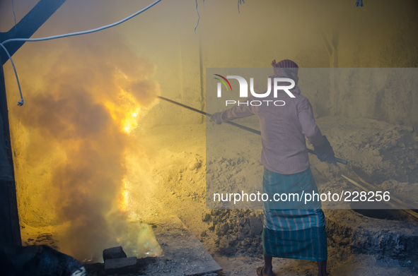 DHAKA, BANGLADESH. Juli  2013. Worker remove the lead slag with a scoop, without any safety protection. the lead dust is verry danger. The m...