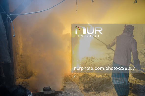 DHAKA, BANGLADESH. Juli  2013. Worker remove the lead slag with a scoop, without any safety protection. the lead dust is verry danger. The m...