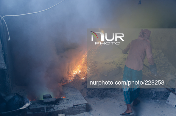 DHAKA, BANGLADESH. Juli  2013. Worker remove the lead slag with a scoop, without any safety protection. the lead dust is verry danger. The m...