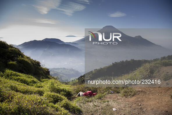 A visitor fell a sleep in front of Mount Sindoro View from Sikunir Mountain, some visitors choose to stay a night before to see the sunrise...