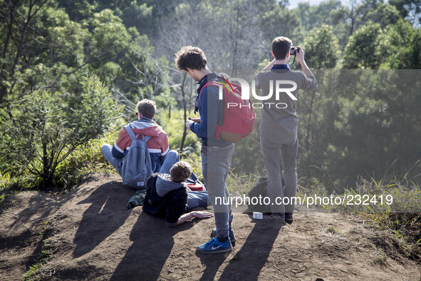 German Tourist enjoying the sun rise from Top of Sikunir Mountain at Dieng. Dieng plateau in Central Java, is part of the district of Banjar...