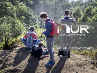 German Tourist enjoying the sun rise from Top of Sikunir Mountain at Dieng. Dieng plateau in Central Java, is part of the district of Banjar...