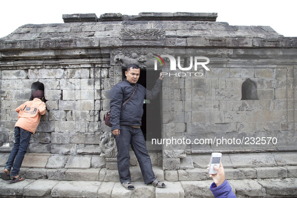 A visitor pose for a mobile phone photo at Temple Complex in Dieng. Dieng plateau in Central Java, is part of the district of Banjarnegara a...