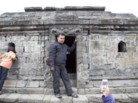 A visitor pose for a mobile phone photo at Temple Complex in Dieng. Dieng plateau in Central Java, is part of the district of Banjarnegara a...