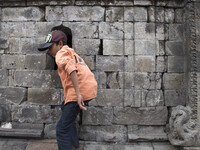 A child with his curiosity to see inside the temple at  Temple complex in Dieng. Dieng plateau in Central Java, is part of the district of B...