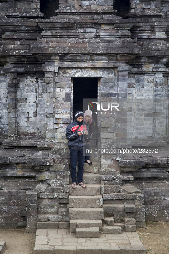 Couples inspect their digital camera after pose at a Temple in Complex Temple at Dieng. Dieng plateau in Central Java, is part of the distri...